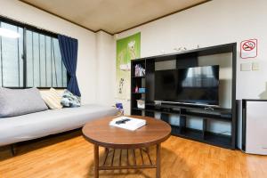 a living room with a large flat screen tv at お宿 しんみち in Nagoya