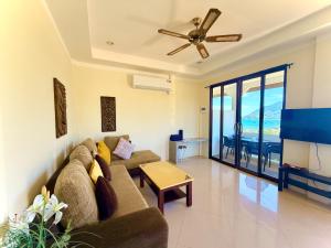 a living room with a couch and a ceiling fan at Viking House Apartment in Ko Tao