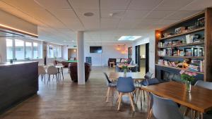 a restaurant with tables and chairs and a bar at Widdy Bay View in Widemouth Bay