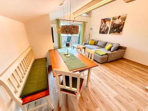 a living room with a table and a couch at VILLAWILLI - Gemütliche Ferienwohnungen in Fischen