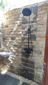a stone wall with a shower and a sink at FURUSATO BUNGALOW Gili Gede in Gili Gede +35 photos