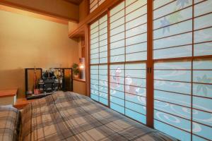 a bedroom with a bed and a large window at お宿 しんみち in Nagoya