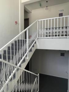 a staircase with white railings in a building at LA MĂRIUCA camere de inchiriat in Moineşti