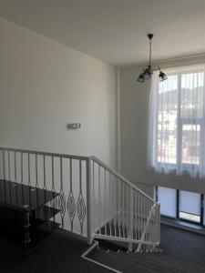 a staircase in a white room with a window at LA MĂRIUCA camere de inchiriat in Moineşti