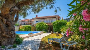 a backyard with a pool and a house at Villa Rossy by Villas Guide in Pavicini