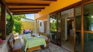 a patio with a table and chairs and a building at Villa Rossy by Villas Guide in Pavicini