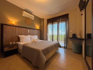 a bedroom with a large bed and a large window at Rodolithos Beach in Stavros