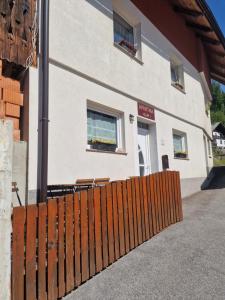a building with a wooden fence in front of it at Apartma Alja Podkoren in Kranjska Gora +23 photos