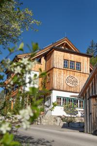 a large wooden house with a white front at Ecologie Grundlsee in Grundlsee