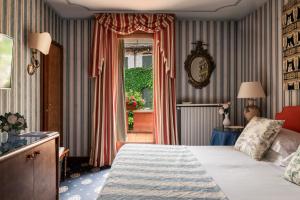 a hotel room with a bed and a window at Villa Abbazia Relais & Chateaux in Follina +77 photos