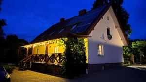 a house with a solar roof with lights on it at Raciborówka in Świętajno
