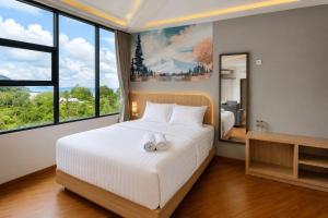 a bedroom with a large bed with two white towels on it at Samara Villa by Sinergi in Tawangmangu +18 photos