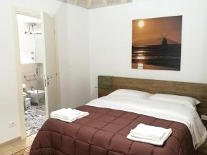 a bedroom with a bed with two towels on it at Primo Piano Riccio Locazione Turistica in Trapani