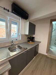 eine kleine Küche mit Spüle und Fenster in der Unterkunft hidden modern studio in Vathý