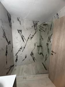 ein Badezimmer mit Dusche und Marmorwand in der Unterkunft hidden modern studio in Vathý