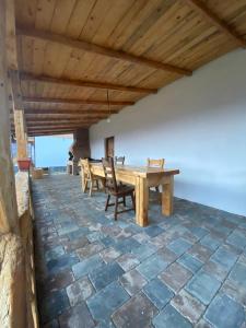 a large patio with a wooden table and chairs at Căsuța Anei in Rîmeţi-Valea Inzelului