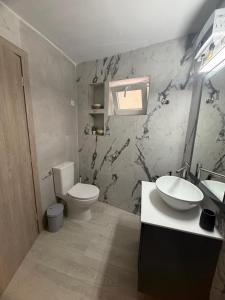 ein Badezimmer mit Toilette und Waschbecken in der Unterkunft hidden modern studio in Vathý