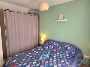 a bedroom with a bed with a quilt on it at Chambre privée proche plages in Plozévet +2 photos
