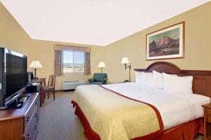 a hotel room with a bed and a flat screen tv at Pinedale Hotel & Suites in Pinedale