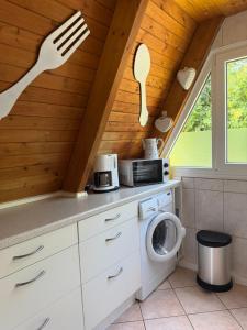 a kitchen with a fork and a washing machine at Ferienhaus Seestern in Damp
