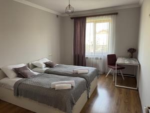 a bedroom with two beds and a desk and a window at Afyan's guest house in Yerevan