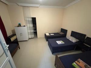a small room with two beds and a refrigerator at Palma Hostel in Batumi