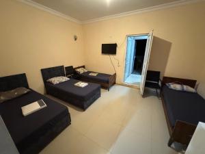 a living room with two beds and a couch at Palma Hostel in Batumi