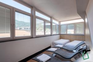 a hospital room with three beds and windows at HOTIDAY Room Collection - Alassio Centro in Alassio