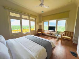 a bedroom with a bed and a tv and windows at Hotel Mashabrum Skardu Free Breakfast Mountain View Family Rooms & Free WiFi in Skardu