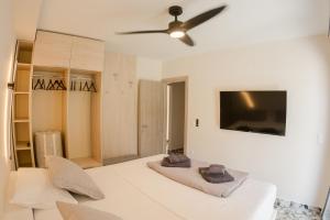 a bedroom with a bed and a ceiling fan at Sweet Suites in Nea Peramos