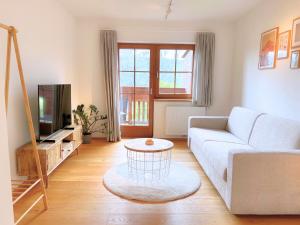 a living room with a couch and a tv at VOM REITER, Ferienwohnung am Bauernhof mit Bergblick und privater Infrarotkabine, Inkl Sommercard und Spielplatz in Schladming