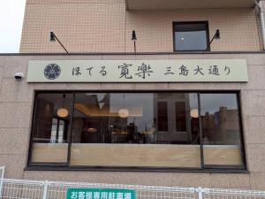 a building with a window with writing on it at HOTEL KAN-RAKU Mishima Main Street in Mishima