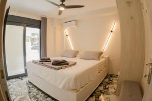 a bedroom with a white bed with a window at Sweet Suites in Nea Peramos