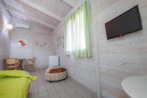 a bedroom with a flat screen tv on a wall at Marechiaro Pool & Restaurant in Paestum