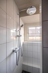 a shower stall in a bathroom with a window at Stadshotel Tante Annie's in Oldenzaal