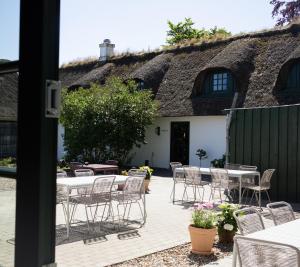 a patio with tables and chairs in front of a building at Nørby Boutique Hotel in Fanø