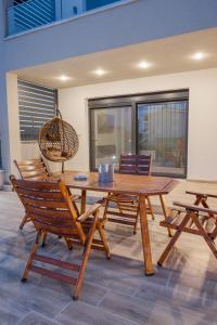 a wooden table and chairs in a room at Sweet Suites in Nea Peramos