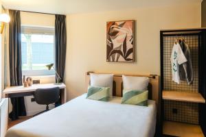 a hotel room with a bed and a desk at Cowool Créteil in Créteil