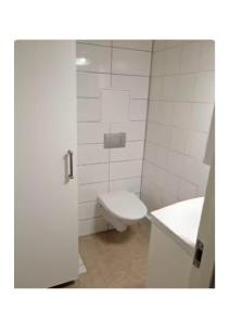 a white bathroom with a toilet and a sink at Central City nest in Haparanda