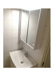 a white bathroom with a sink and a mirror at Central City nest in Haparanda