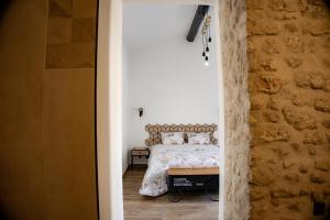a bedroom with a bed and a stone wall at A la beun'escale in Belluire +42 photos