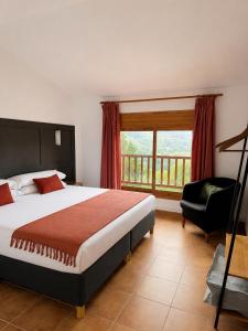 a bedroom with a bed and a chair and a window at Hotel Casa Eira B&B in La Molina +44 photos