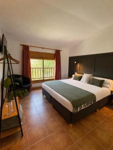 a bedroom with a large bed and a window at Hotel Casa Eira B&B in La Molina