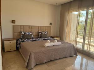 a bedroom with a bed with two towels on it at Villa 4 chambres Bouznika Bay by Saloua in Bouznika +37 photos