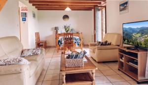 a living room with couches and a flat screen tv at Gite De La Mortagne in Mortagne