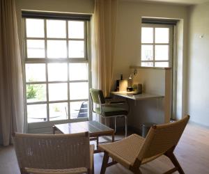 a living room with chairs and a table and a window at Nørby Boutique Hotel in Fanø