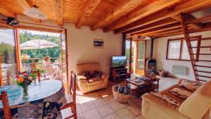 a living room with a table and a tv at Gite De La Mortagne in Mortagne
