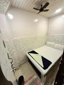 a small white room with a bed in it at Hotel firdous in Mumbai