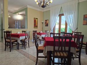 a restaurant with red tables and chairs and a chandelier at B&B TENUTA BIANCA in Oliveto Citra