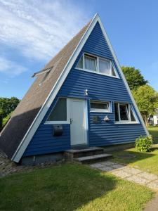 a blue house with a pointed roof at Ferienhaus Seestern in Damp